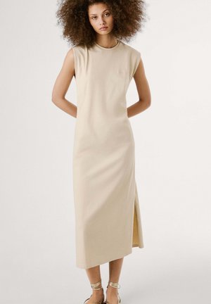 Robe sans manches beige avec un col rond, design à mi-genoux et une fente sur le côté ; texture lisse ; peu de détails.