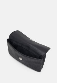 Clutch nera Calvin Klein con motivo a monogramma, apertura a pattina e chiusura magnetica che mostra l'interno foderato in tessuto.