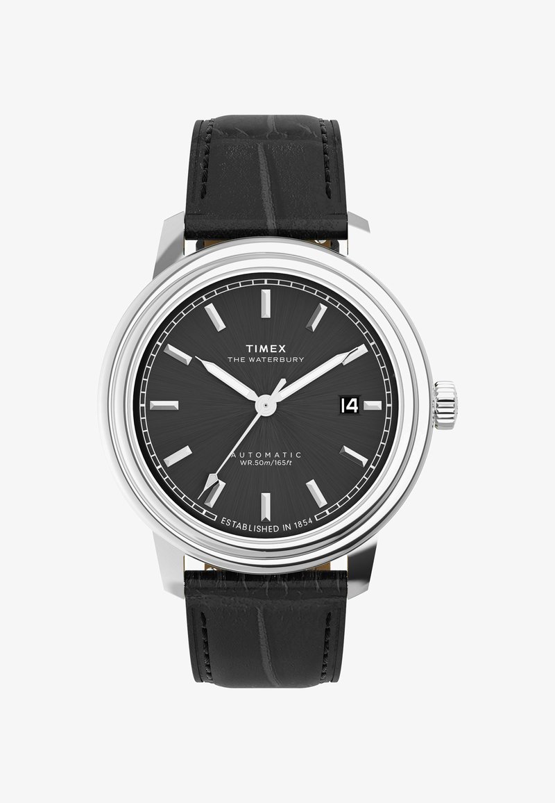 Timex Waterbury automaatne kell musta tekstuuriga nahkrajal, hõbedases korpuses ja mustal kellaplaadil, millel on hõbedased tunni markerid ja kuupäeva näit.