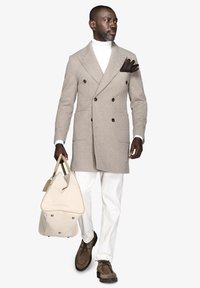 Beige fiskebensmønster frakke, hvid turtleneck, hvide bukser, brune ruskindsko. Beige taske med kontrasterende syninger og hardware-detaljer.