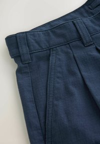 Navy blue trousers with a textured fabric, featuring a flat front, belt loops, and stitched detailing along the waistband and pleats.