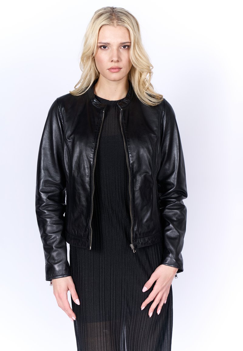Zwarte leren jas met een ronde halslijn, ritssluiting en lange mouwen. Soepele textuur en aansluitend ontwerp met een cropped snit.