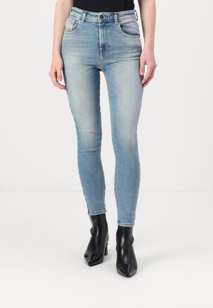 Light blue high-waisted skinny jeans with five pockets, slight fading, and a soft denim texture, paired with black high-heeled boots.
