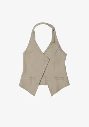 Gilet beige à col halter avec des détails en clous argentés le long des bords avant et deux petites poches fentes horizontales.