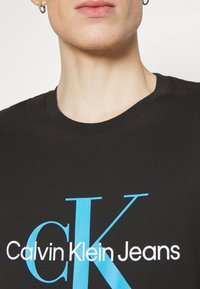 Calvin Klein Jeans SEASONAL MONOLOGO TEE - Apdrukāts T-krekls - black
