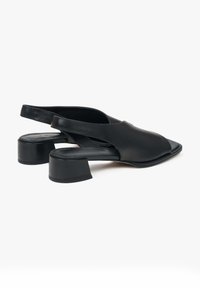 Zwarte leren slingback schoenen met een vierkante neus en blokhak. Gladde textuur en minimalistisch ontwerp, met een open achterkant.