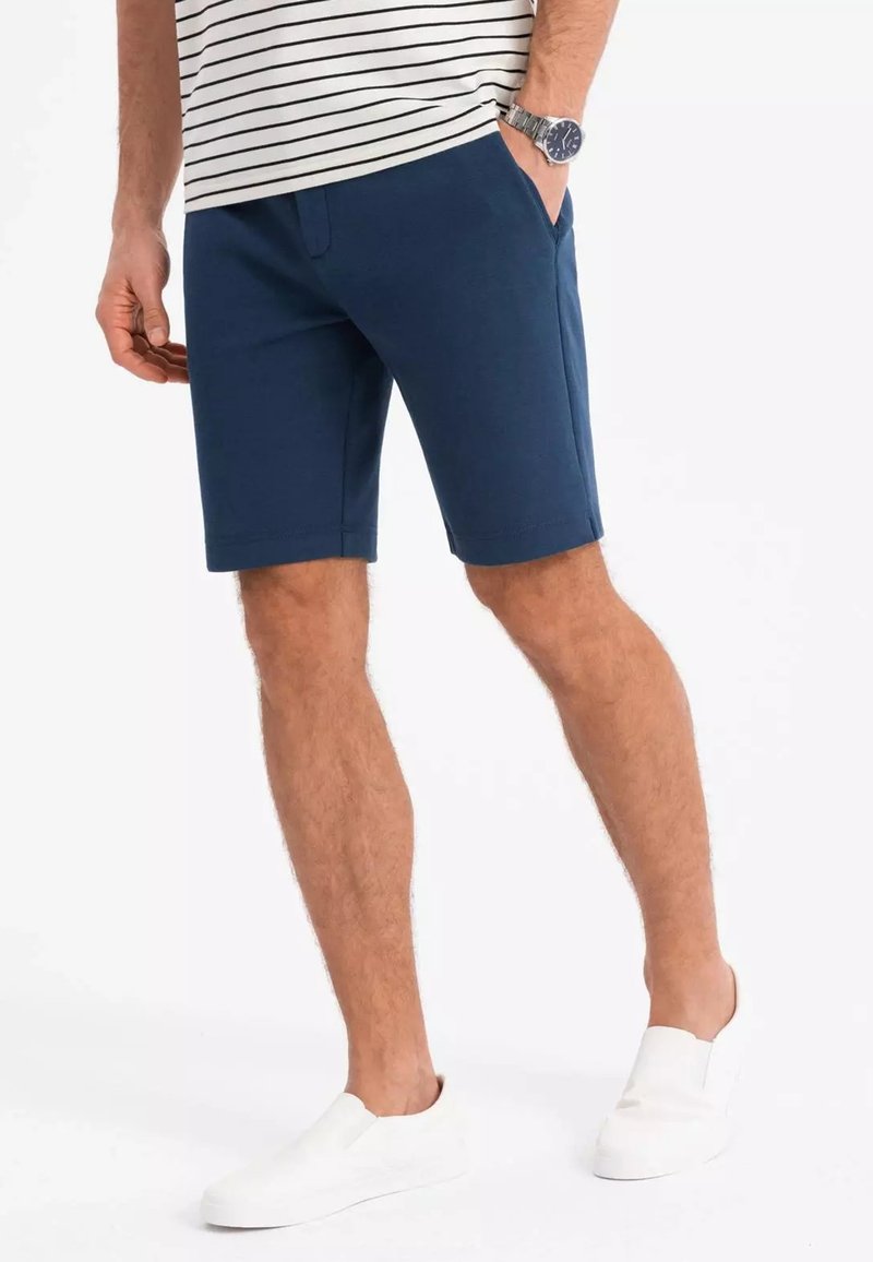 Navyblaue Shorts aus weichem Stoff, mit zwei Seitentaschen. Mit einem subtilen elastischen Bund für zusätzlichen Komfort gestaltet.