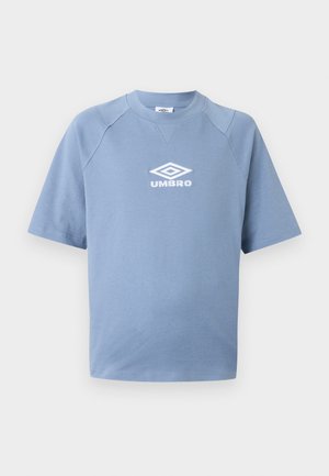 T-shirt bleu clair à manches courtes avec col rond et logo Umbro blanc centré sur la poitrine sur un fond uni.