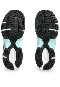 Semelles de chaussures de sport noires et vert menthe avec un dessin de semelle, présentant des accents surélevés et une section intermédiaire lisse blanche.