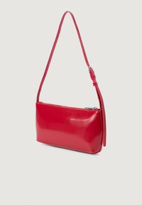 Rød skinn skulderveske med en glatt, blank overflate. Har glidelås og en smal, justerbar stropp for allsidig bæring.