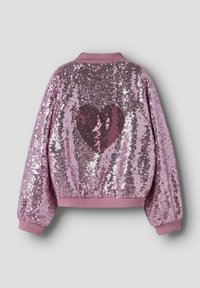 Roza bomber jakna s sequins oblogo in rebrastim ovratnikom. Na hrbtni strani ima velik črn in roza srčast vzorec. Mehka, teksturirana površina.