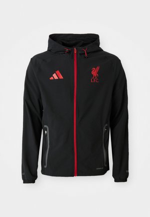 Black jacket with a red zip, featuring a hood, Adidas logo, and Liverpool FC emblem. Designed with side pockets and elastic cuffs.