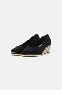 Scarpe wedge in suede nero con punta rotonda, tacco wedge testurizzato beige e suola in gomma. Design semplice senza hardware o accenti visibili.