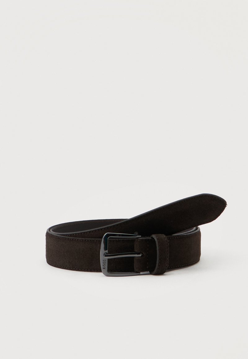 Ceinture en daim brun foncé roulée avec boucle métallique noire rectangulaire sur un fond clair uni.