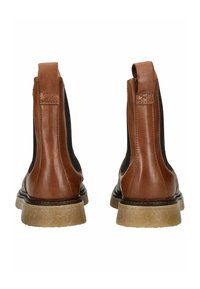 Bottes chevilles en cuir marron avec des panneaux élastiques sur les côtés, bout rond et semelle en caoutchouc texturée, avec une languette à l'arrière.