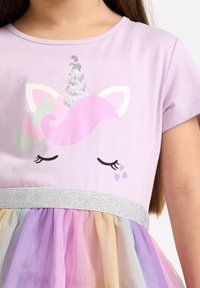 Lila t-shirtklänning med en enhörningsgrafik med paljettbesatt horn, silverglittrigt midjeband och kjol i flerfärgat tyll.