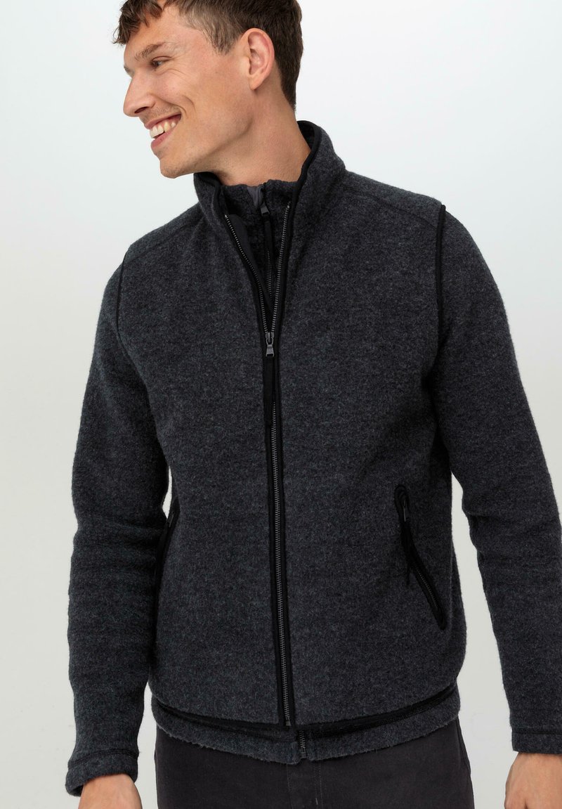 Fleecejacke in Dunkelgrau mit hohem Kragen und vollem Reißverschluss. Verfügt über zwei seitliche Taschen mit Reißverschlüssen und strukturiertem Stoff.