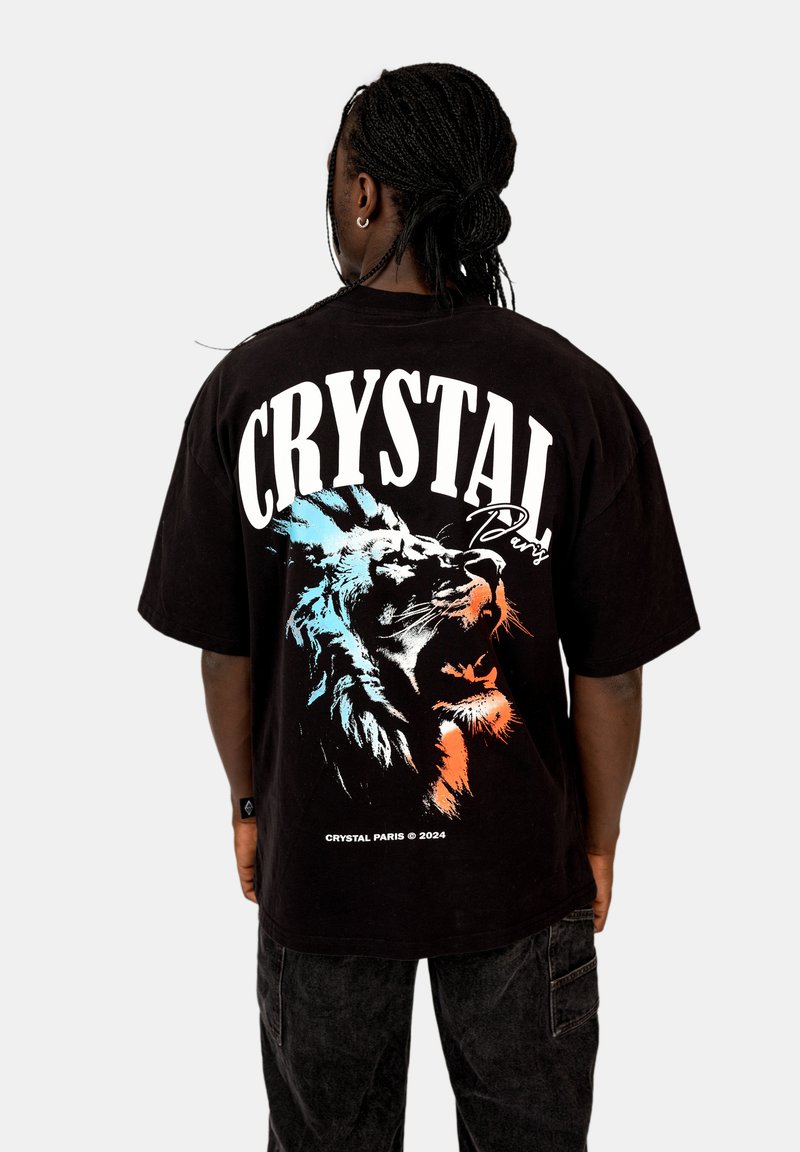 Černé volné tričko s velkým potiskem barevného lva a textem "CRYSTAL PARIS" na zádech. Volný střih, krátké rukávy.