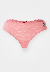 Lace thong in soft pink with scalloped edges, featuring a small logo tag and a delicate pattern throughout.