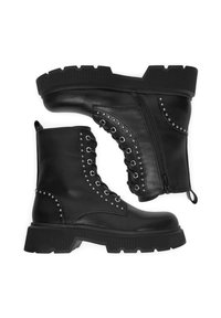 Czarne skórzane buty wojskowe z grubą podeszwą, bocznym zamkiem błyskawicznym i ćwiekowanymi detalami wzdłuż sznurowadeł i górnej części buta. Teksturowana gumowa podeszwa.