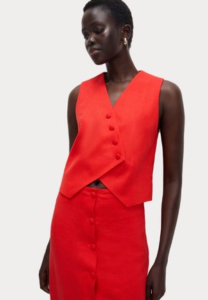 Rotes Leinen-Crop-Top mit V-Ausschnitt und fünf Frontknöpfen, kombiniert mit einem passenden roten Rock mit durchgehender Knopfleiste. Glatte Textur.