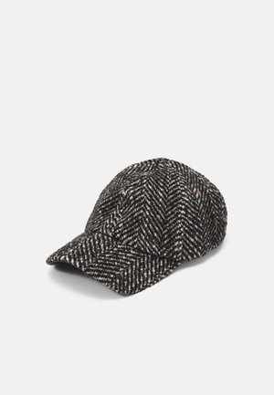 Casquette de baseball en laine à motif chevrons noir et blanc avec une visière courbée, présentée en angle sur un fond blanc.