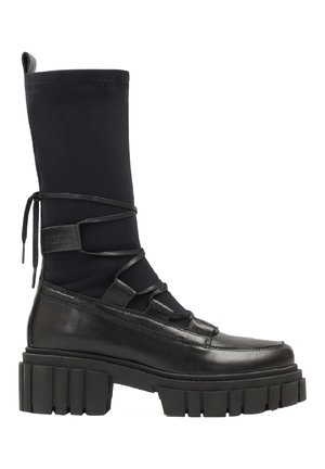 Stivale nero fino al ginocchio in una combinazione di cuoio liscio e tessuto elasticizzato, con lacci sulla parte anteriore e suola spessa e rigata.