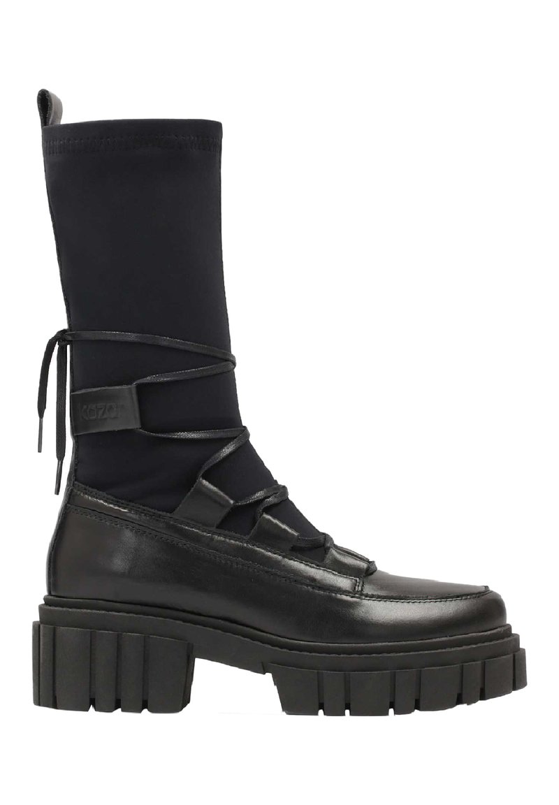 Bota negra hasta la rodilla que presenta una combinación de cuero suave y tejido elástico, con cordones en el frente y una suela gruesa y estriada.