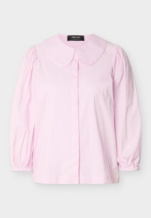 Blouse rose clair à manches longues avec col arrondi, épaules froncées, poignets élastiques et fermeture boutonnée cachée à l'avant, présentée sur un fond blanc.