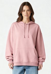 Felpa con cappuccio rosa con coulisse, vestibilità oversize, tasca frontale a marsupio, polsini e orlo a coste, realizzata in morbido tessuto di cotone.