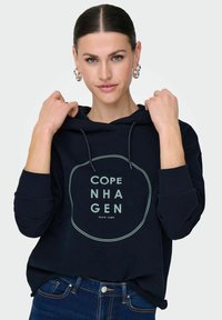 Felpa navy con tasca frontale, cappuccio con cordoncino e stampa circolare "Copenhagen" in crema. Realizzata in tessuto morbido con polsini a coste.