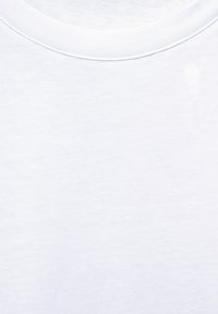 Camiseta de algodón blanca con un diseño de cuello redondo, con una textura suave y un sutil detalle de costura alrededor del cuello.