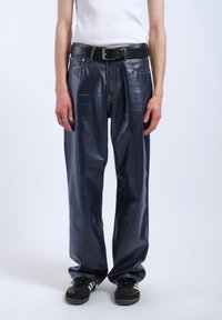 Navy faux leather trousers with a straight leg design, featuring visible stitching, belt loops, and a black belt. Textured finish, casual fit.