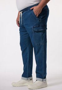 Ciemnoniebieskie dżinsowe spodnie cargo z elastycznym pasem, sznurkiem do regulacji, bocznymi kieszeniami i wywiniętym dołem. Teksturowana tkanina z luźnym krojem.