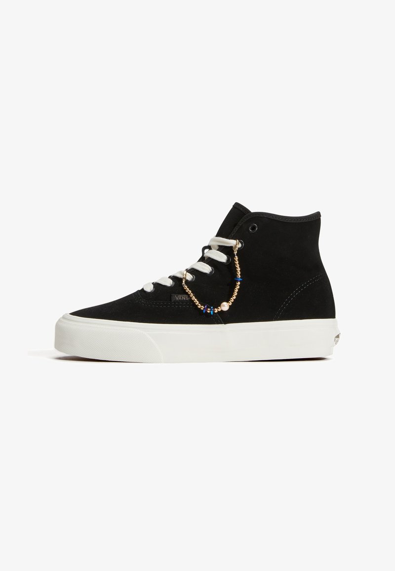 Μαύρο sneaker ψηλού πάτου με λευκή σόλα και κορδόνια, διακοσμημένο με μικρή χρυσή και μπλε αλυσίδα από χάντρες στο πλάι.