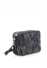 Borsa a tracolla in tela blu navy con motivo camouflage, hardware argentato, chiusura superiore con zip e tracolla regolabile. Dettagli della superficie texturizzati.