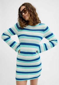 Pleteni haljina s horizontalnim prugama u nijansama plave, mente i bijele. Dugi rukavi, ovalni izrez i prilagođeni dizajn.
