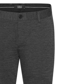 Graue, strukturierte Hosen mit Knopfverschluss, die ein schlichtes Design und dezente Nähdetails aufweisen. Das Etikett trägt die Aufschrift "CLEAN CUT COPENHAGEN."