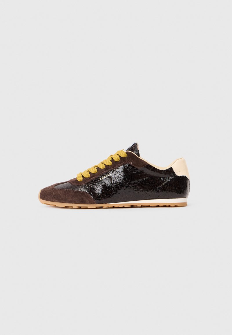 Sneakers sznurowane w czarnej lakierowanej skórze i brązowym zamszu, z żółtymi sznurówkami, niskim profilem i teksturowanym wykończeniem.