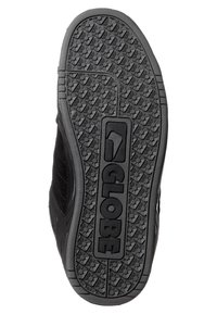 Black sneaker sole featuring a textured surface with geometric patterns and the logo "GLOBE" prominently displayed in the center.