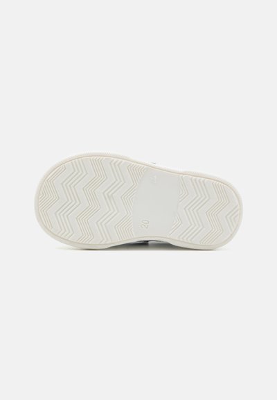 Suola di sneaker bianca con motivo a zig zag, gomma testurizzata per una buona presa, caratterizzata da un'area centrale liscia con il numero "20" in rilievo.