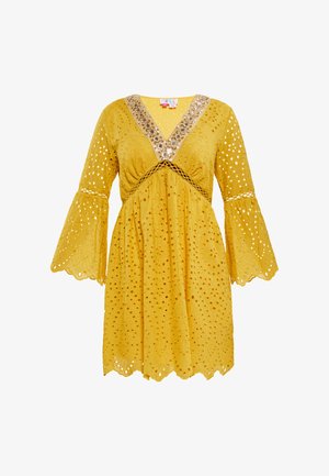 Sárga ruha V-nyakú kivágással, csipke részletekkel és harangujjakkal. Az anyag lyukacsos mintázatú és cakkos szélű.