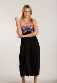 Schwarzes Maxikleid mit einem bunten, trägerlosen Oberteil, das mit kunstvollen Mustern und Perlenakzenten verziert ist, entworfen für eine lässige Passform.