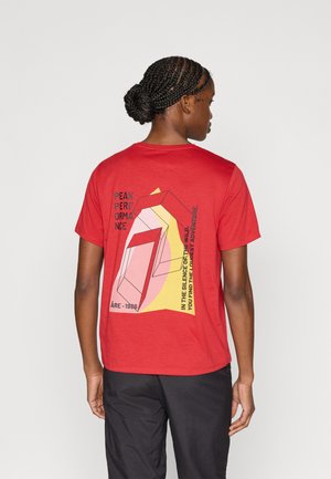 Czerwona koszulka z krótkim rękawem z grafiką przedstawiającą geometryczne kształty oraz tekst w kolorach czarnym, żółtym i różowym na plecach.