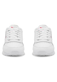 Baltos sportbačiai su lygiu odiniu viršumi, apvalia nosimi ir perforuotomis detalėmis. Baltos raištelės ir pilki akcentai. Guminis padas.