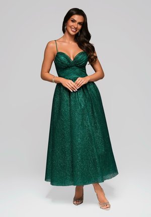 Robe maxi satin vert émeraude avec un corsage ajusté, décolleté en V et fines bretelles ; présente une jupe fluide avec un léger effet scintillant.