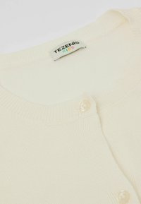 Cremfarbener Kinderpullover mit geripptem Muster, Rundhalsausschnitt und einem einzelnen, runden Perlenknopf auf der Vorderseite. Etikett: Tezenis Kids.