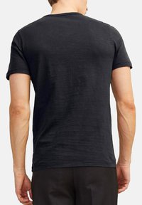 Schwarz, kurzärmeliges T-Shirt aus weichem Stoff, mit klassischem Rundhalsausschnitt und entspannter Passform. Glatte Textur mit minimalen Details.