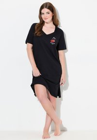 Vestito da notte in cotone nero con maniche corte e scollo a V. Presenta un design grafico di ciliegie sul petto. Orlo leggermente curvo con spacchi laterali.