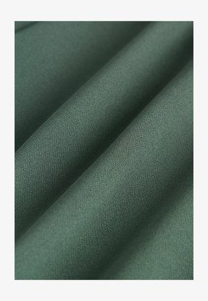 Zaļš audums ar gludu, matētu tekstūru, kurā ir salocītas kārtas. Materiāls izskatās viegls ar nelielu spīdumu.